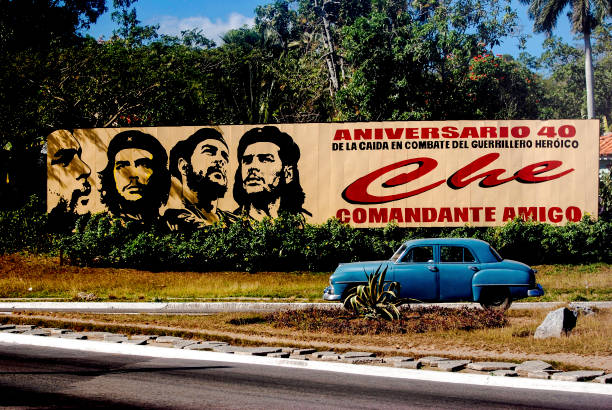 Che Guevara road sign in Pinar del Rio, Cuba Pinar del Rio, Cuba - January 8, 2008: Billboard celebrating Che Guevara with blue classic car driving by guerrilla warfare photos stock pictures, royalty-free photos & images