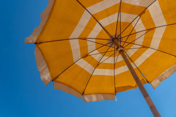 istock a bright yellow parasol stretched out on the beach 1164602433