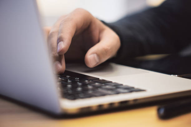 istock Closeup of man using laptop on workspace 1164602709