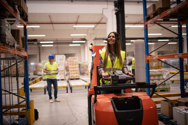 istock Warehouse worker in forklift handling palette with goods in storage area. Industrial worker organizing goods storage and distribution to the market. 1164605856