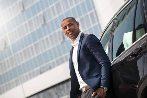 istock Young man standing near car hand in pocket looking camera thoughtful bottom view 1164612691