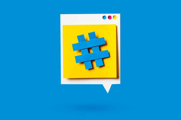 istock Paper cutout of hashtag symbol on a yellow speech bubble on blue background. Concept of social media and digital marketing. 1164627334