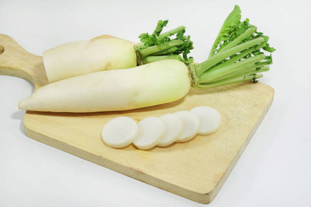 slices of white radish (raphanus sativus) on cutting board isolated on white