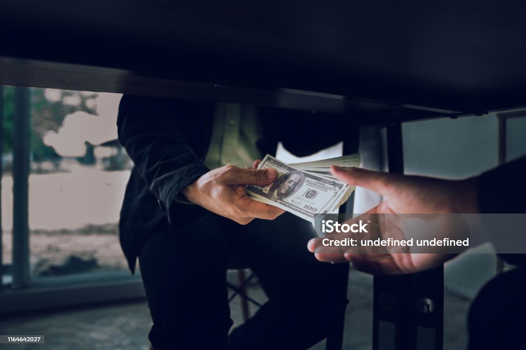 Businessmen are bribing officials to achieve their goals quickly and without arguments Businessmen are bribing officials to achieve their goals quickly and without arguments. Bribing Stock Photo