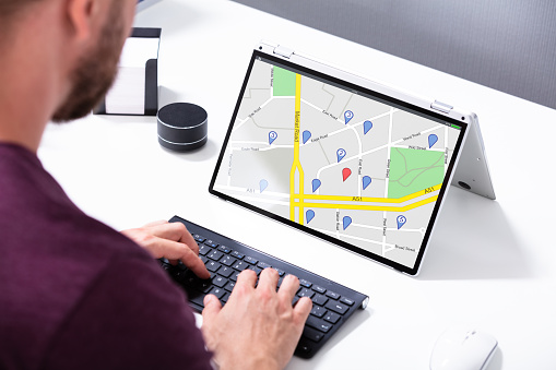 Close-up Of A Man Using GPS Map With Navigation Pointers On Laptop