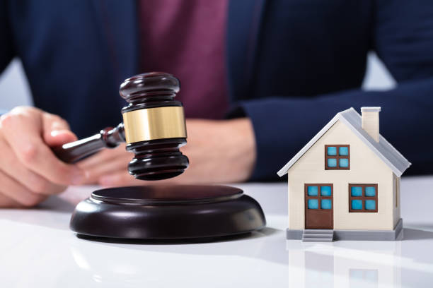 istock Judge Striking Gavel Near House Model 1164644175