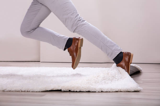 istock Man Stumble In A Carpet Near Ladder 1164644363