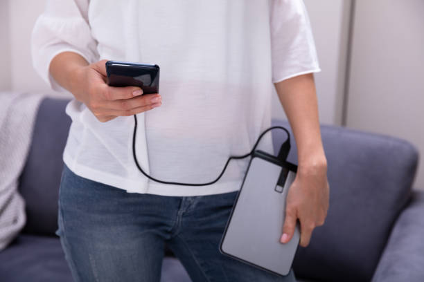 istock Woman Holding External Hard Disk And Mobile Phone 1164645535