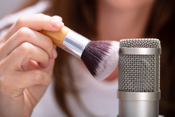 Woman using brush to make ASMR sounds Woman using brush on microphone to make ASMR sounds meridian mississippi stock pictures, royalty-free photos & images