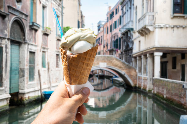 istock Hand Holding Ice-cream Cone On Street 1164645917