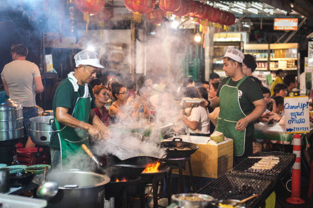 シェフはヤオワラトロード、バンコク、タイの鍋で屋外で調理します - thai cuisine wok food thai culture ストックフォトと画像