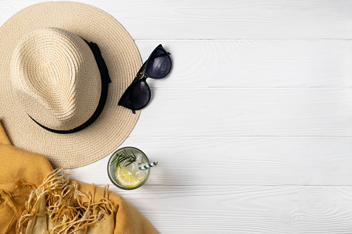 Summer beach pool composition with hat sunglasses refershing drink on wooden background