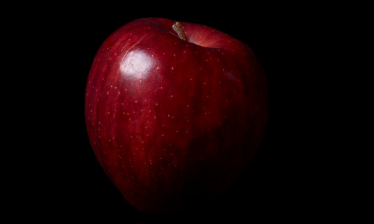 Red delicious on black background.