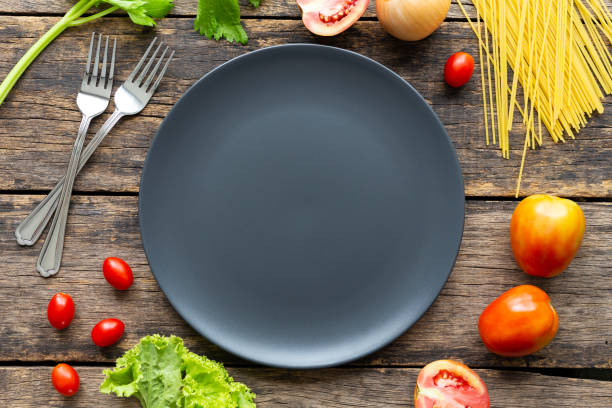istock Spaghetti on black plate on wooden background. top view 1164653780