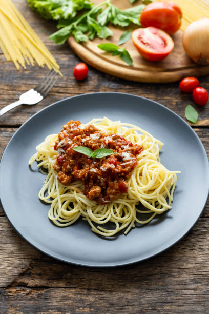istock Spaghetti on black plate on wooden background. top view 1164653785