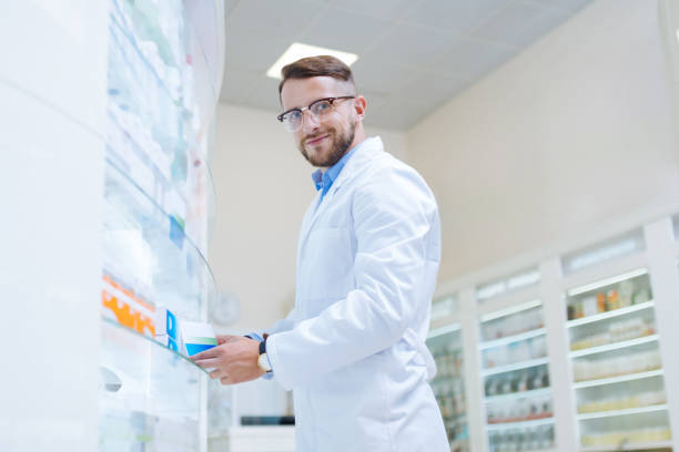 istock Joyful brunette man working in modern pharmacy 1164653917