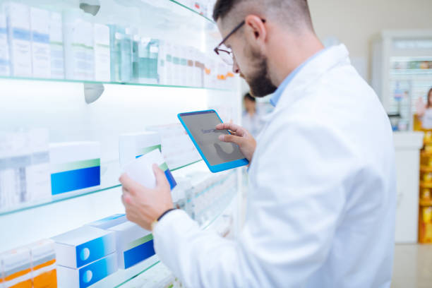 istock Serious brunette chemist searching information about pills 1164653926