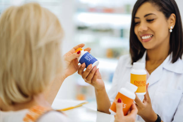 istock Professional cute apothecary consulting her mature client 1164654004