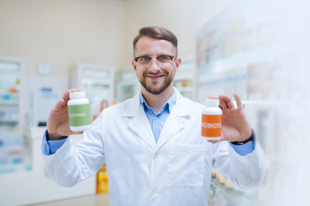 istock Cheerful young bearded apothecary giving useful recommendations 1164654033
