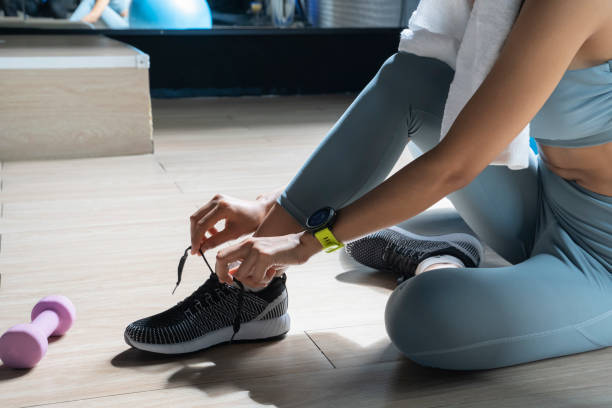 istock Woman tying shoelaces at gym. 1164656022