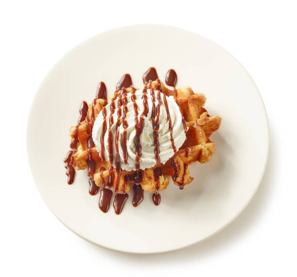plate of belgian waffle dessert with cream and chocolate sauce, top view