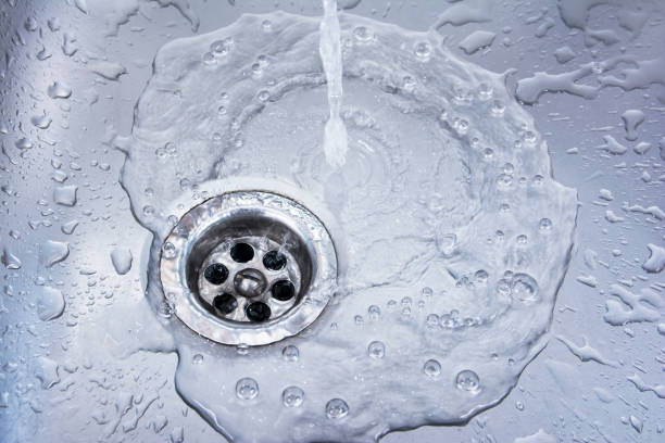 água que drena no fundo do dissipador. dreno de fluxo da água no lavatório - drop faucet water sink - fotografias e filmes do acervo