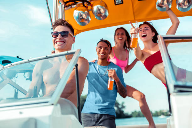 istock Handsome young man driving a motorboat with friends 1164659941