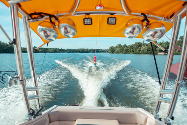 soddisfatta ragazza dai capelli lunghi wakeboard mentre segue un motoscafo - wakeboarding foto e immagini stock