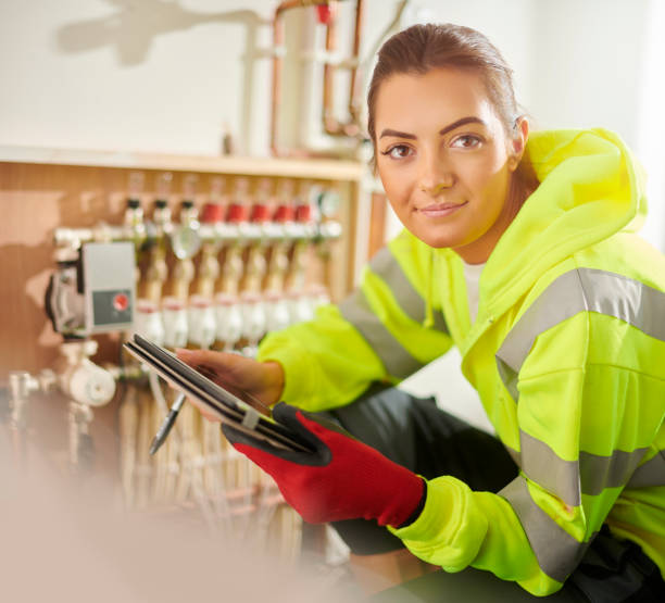 female plumber portrait young woman finishing underfloor heating installation heating engineer stock pictures, royalty-free photos & images