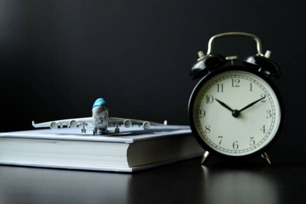 istock Close-up of model aeroplane, a book, a clock  & computer keyboard 1164662385
