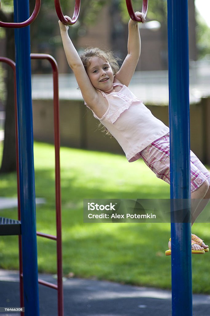 Una niña jugando en el patio de juegos - Foto de stock de Actividad libre de derechos