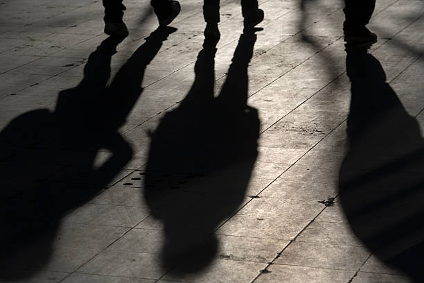 istock shadow over three people walking on the street 116466615