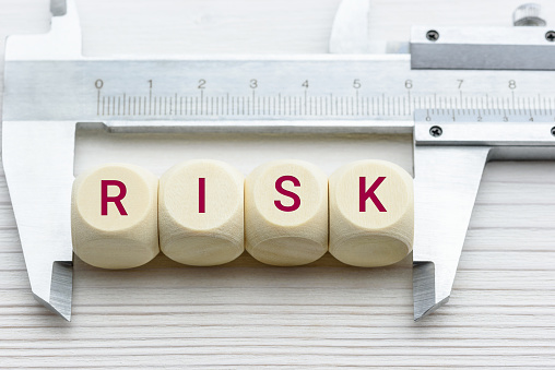 Evaluación de riesgos / análisis de riesgos y concepto de gestión : Palabras RISK en bloques de madera y una pinza vernier con escalas, representan la evaluación del riesgo financiero de un inversor involucrado en acciones, mercado de bonos photo