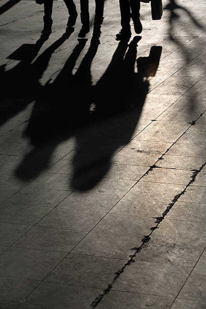 istock sun casting shadow over three people walking on the street 116467139