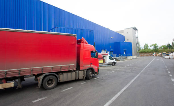 istock red truck discharging goods in warehouse. 1164672404