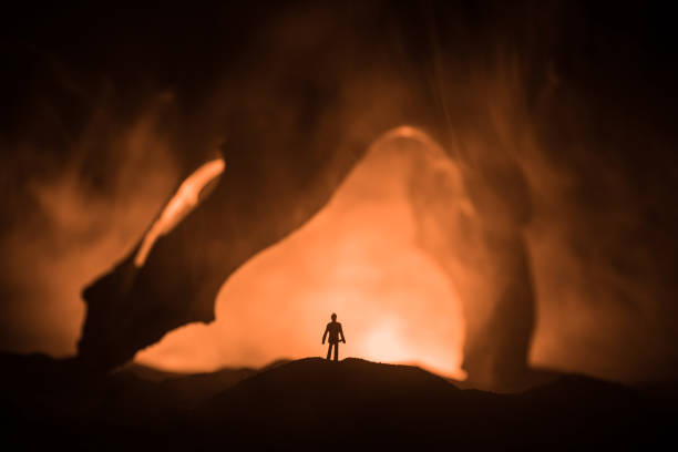 istock Artwork decoration with animal bone. Silhouette in an underground abandoned crypt. man standing in front of a cave entrance 1164674285