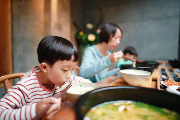 boy eats rice noodles with chopsticks - asian cuisine food asian ethnicity vietnamese cuisine imagens e fotografias de stock