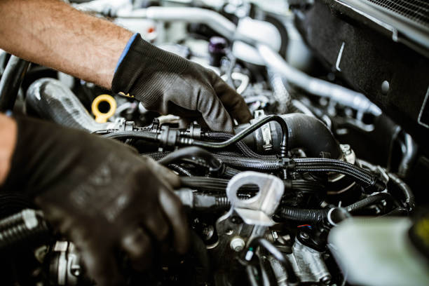 close up of a mechanic examining car pump in a workshop. - diesel engine imagens e fotografias de stock