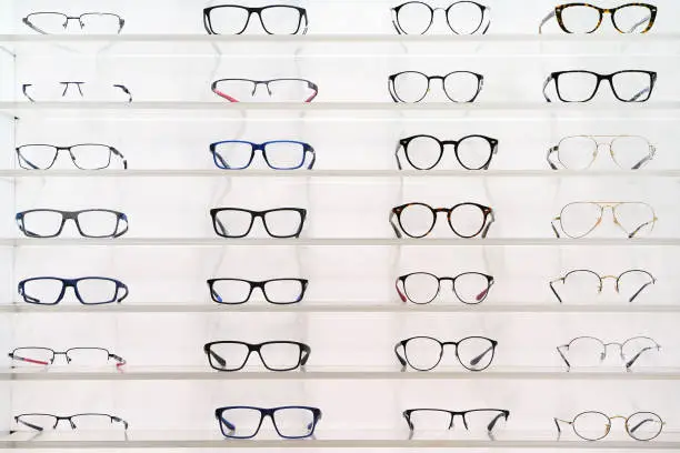 Stand with glasses in the store of optics, eye concept. Close-up many glasses on a stand.