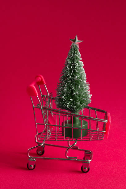 istock small bauble christmas tree in a shopping cart on a pink background 1164677663