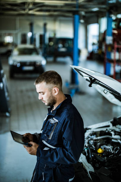 istock Auto repairman working on digital tablet in a workshop. 1164677811