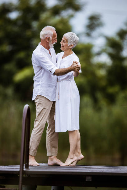 Romantic dance on a pier! Happy senior couple enjoying in romantic dance on a pier. middle aged couple dancing stock pictures, royalty-free photos & images