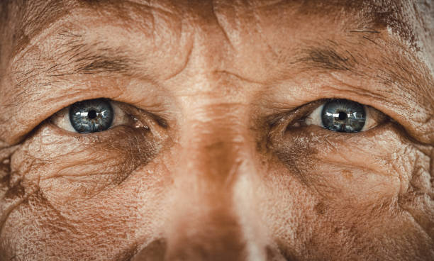 Blue-eyed senior man. Close up of senior man's blue eyes looking at camera. extreme close up stock pictures, royalty-free photos & images