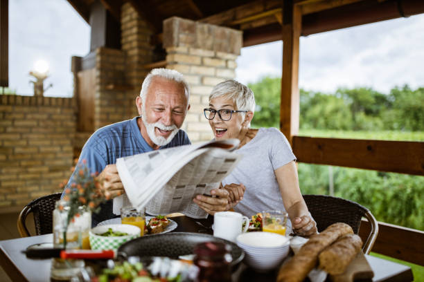 istock Surprised senior couple reading newspapers during breakfast on a terrace. 1164678810