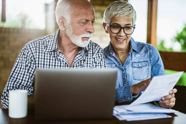 istock Mature couple paying their bills over computer on a terrace. 1164679710
