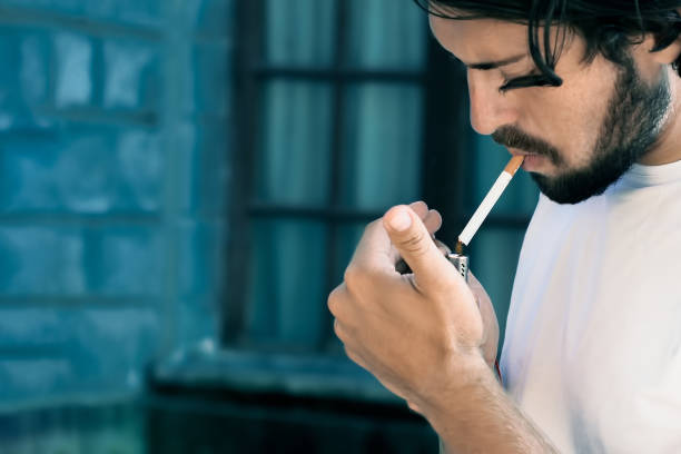 istock Modern young man with beard he lights a cigarette, toning 1164683539