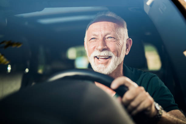 彼の�新しい車で楽しんでいる陽気な先輩の男。 - attractive male confidence satisfaction happiness ストックフォトと画像