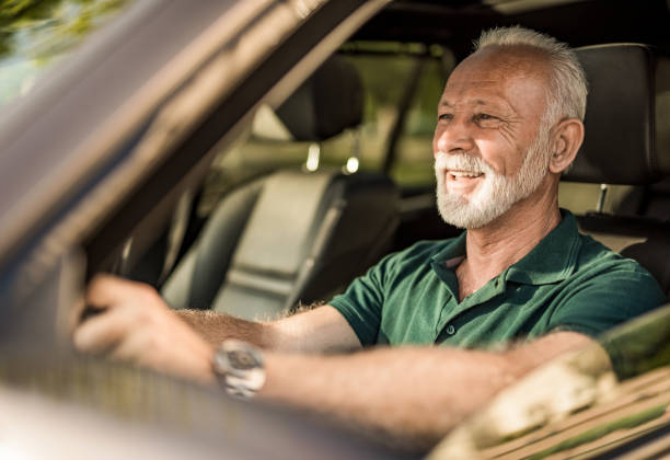 istock Senior man having fun in his new car. 1164689299