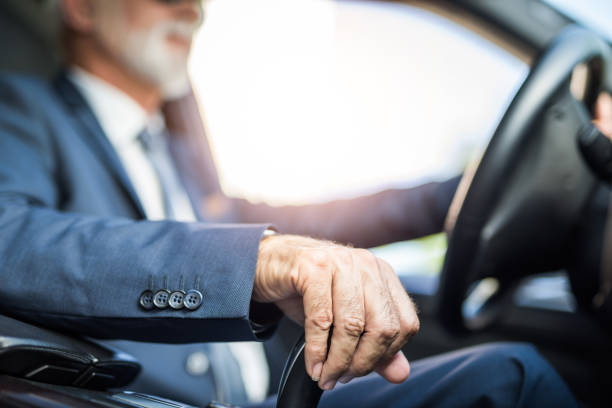 istock Senior businessman driving a car hand close up. 1164689385
