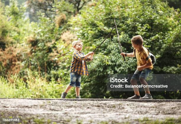 Two Boys Playing Fight With Wooden Swordschildhood Concept Stock Photo - Download Image Now